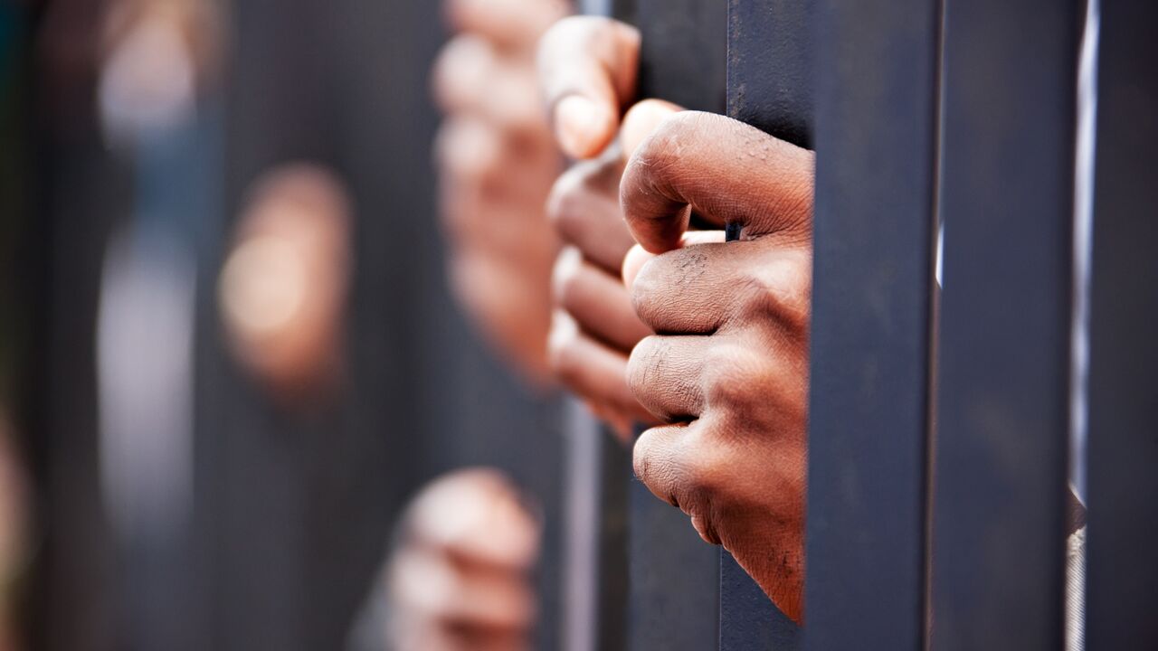 group-hands-people-behind-bars