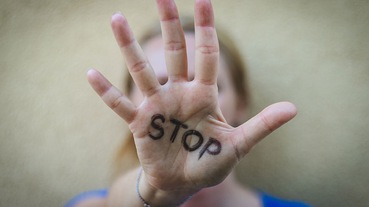Main de femme avec stop écrit sur la paume